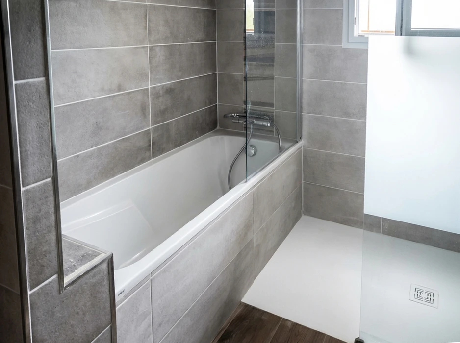 Salle de bain moderne avec baignoire encastrée blanche, paroi de douche en verre trempé fixe et pivotante