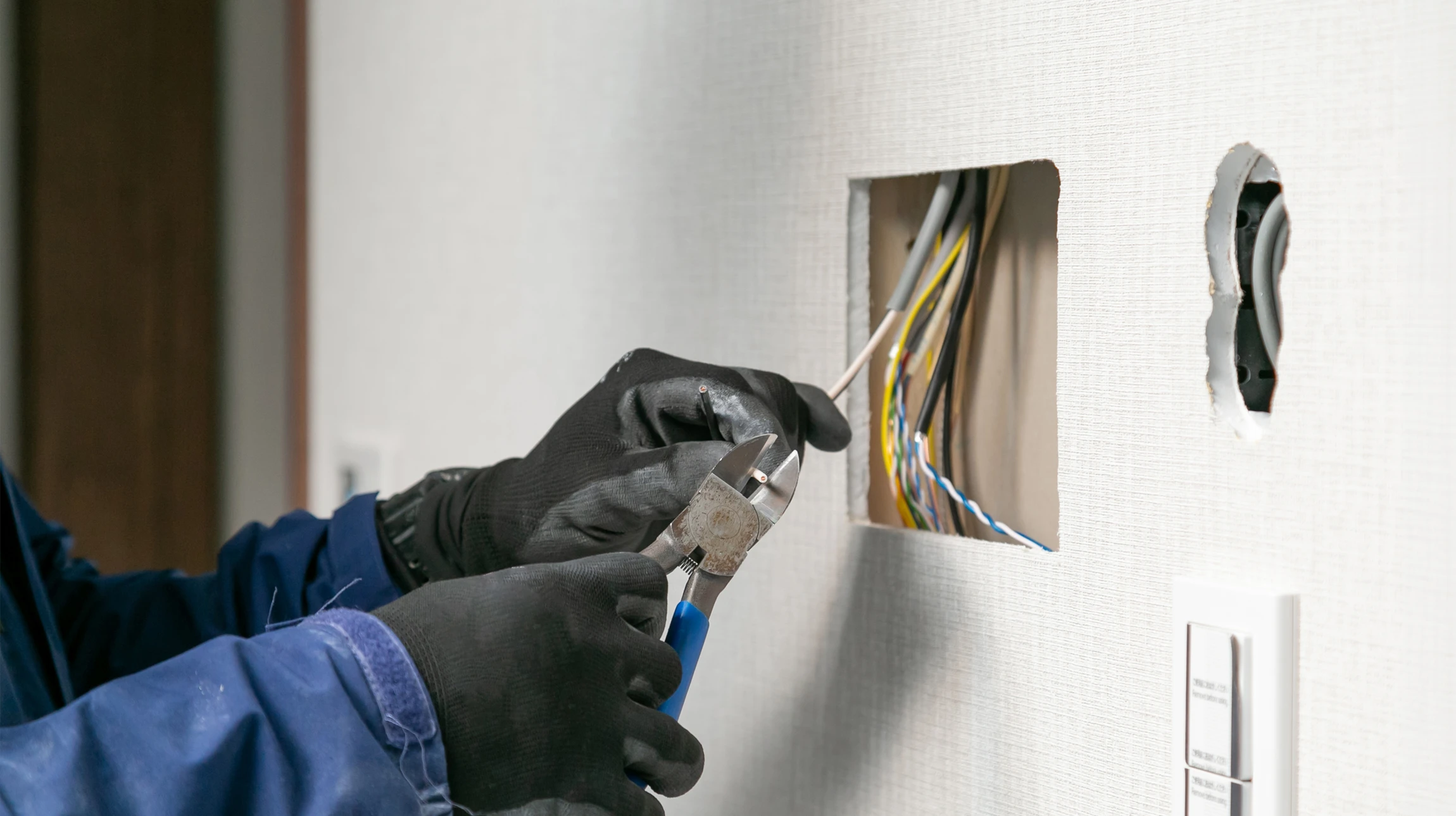 Électricien professionnel installant un interrupteur mural dans un intérieur résidentiel